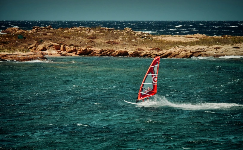 a person windsurfing out on a very choppy ocean