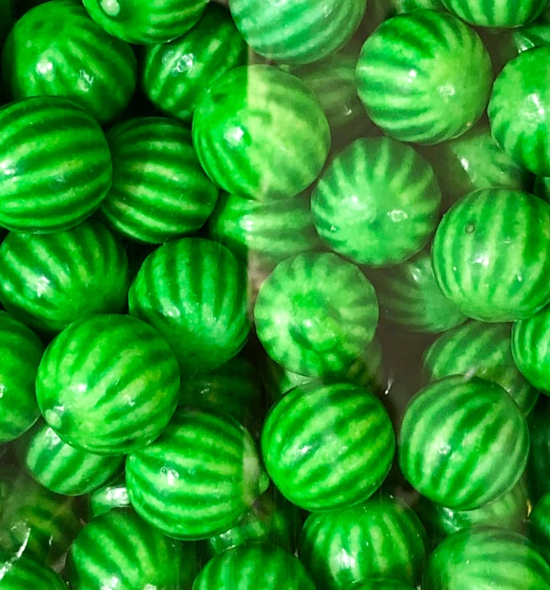 there are many green striped watermelon halves in this pograph