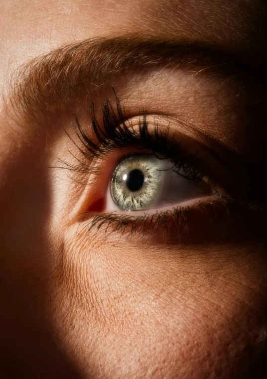 a person with blue eyes and brown hair looking at soing