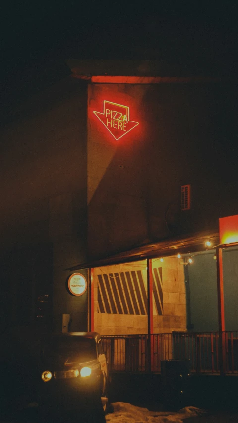 a red neon sign is seen above a store