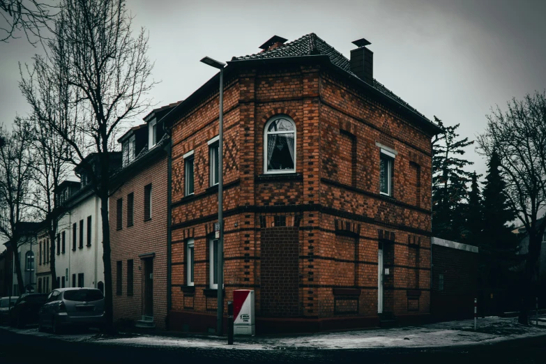 a brick building in a neighborhood next to trees