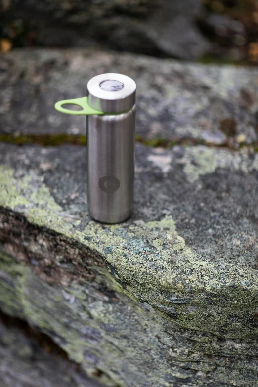 a lighter with a lighter stick is sitting on some rocks