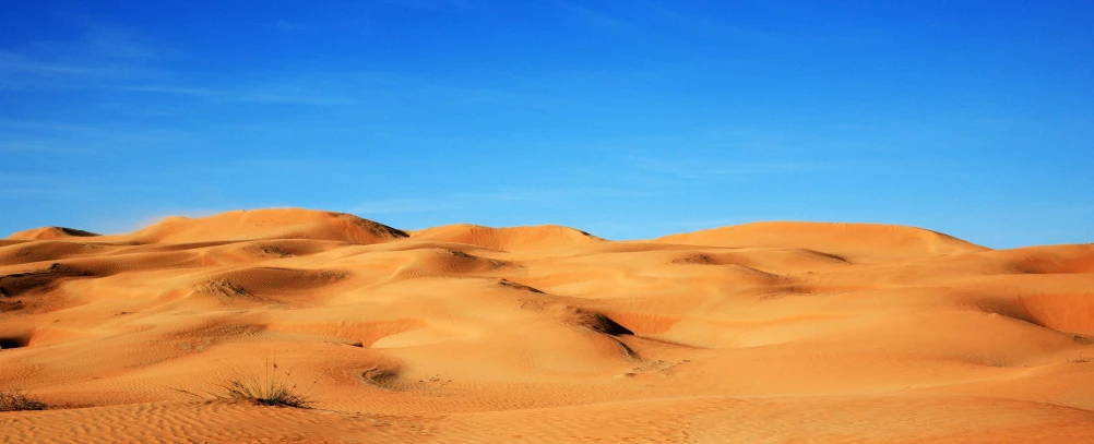 there is a hill of sand under the blue sky