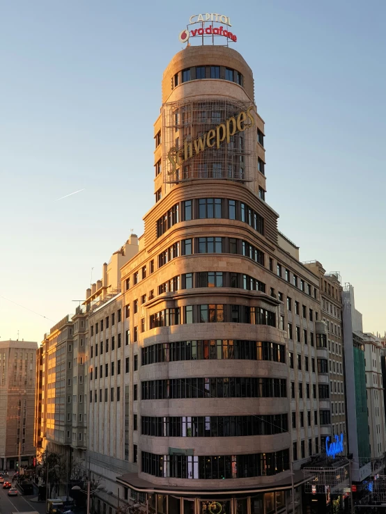 a tall building in a city with a sign on the top of it