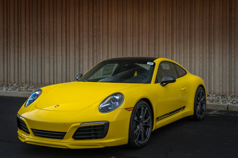 a yellow porsche sports car parked in front of a building