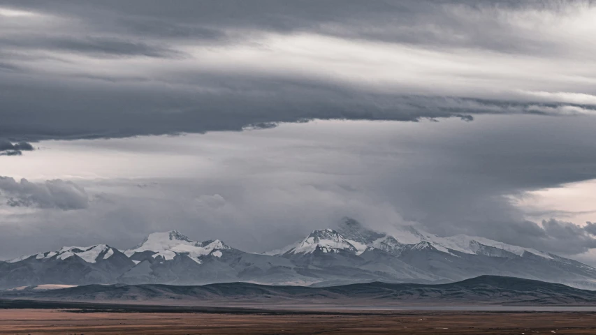 the sky has clouds and a mountain in the background