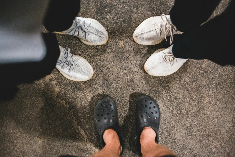 the legs of two people who are wearing shoes standing in the middle of a circle