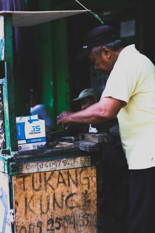 an older man using a small street food cart