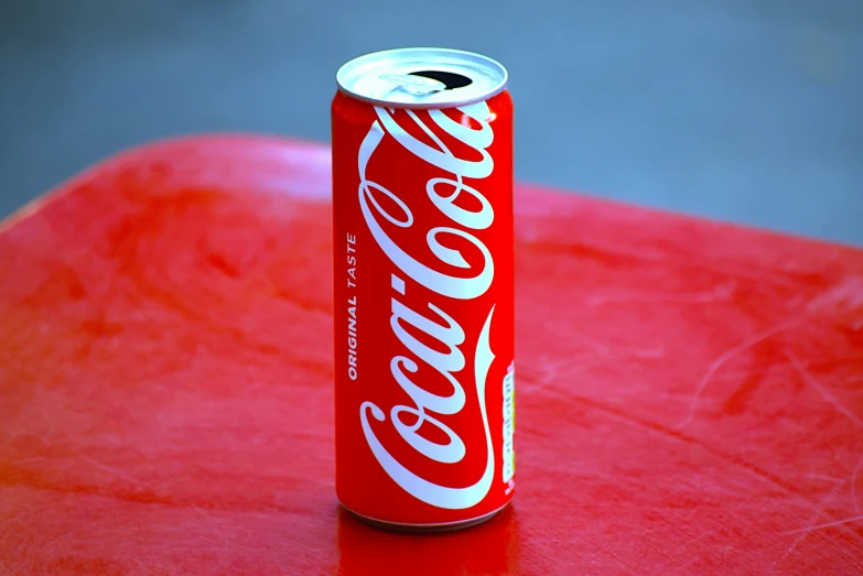 an open can of soda sits on top of a table