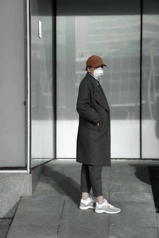 a man wearing glasses stands in front of a glass building