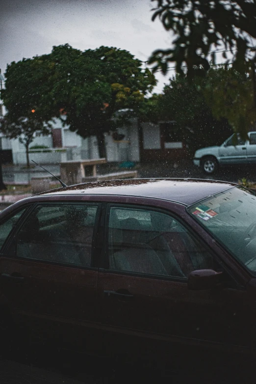 cars parked on the side of the road in the rain