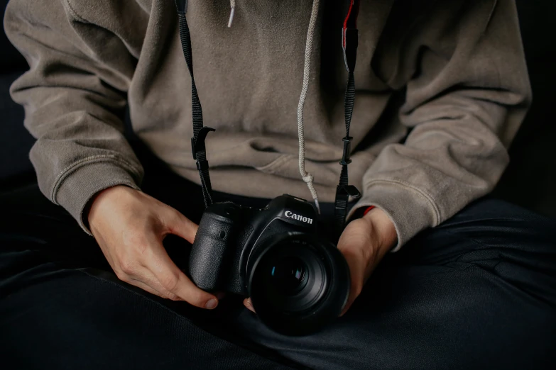 man with camera strapped to his wrist, holding body and hands