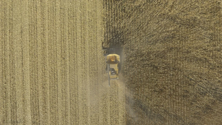 an aerial view of a farmer and his combine at work