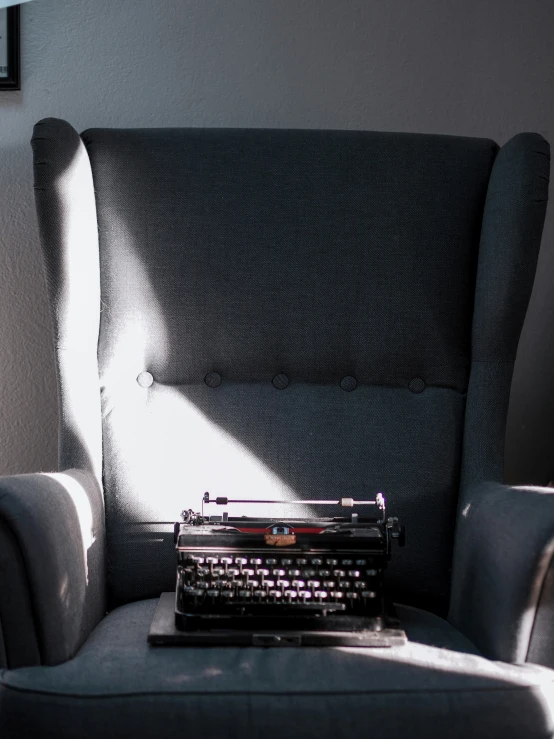 a blue chair with a black and white typewriter on it