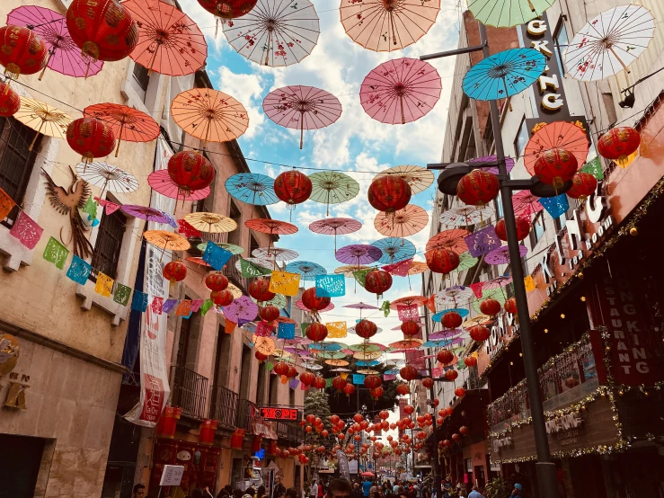 a street full of hanging colored umbrellas