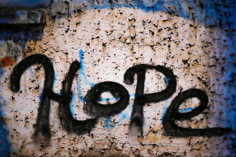 a sign with hope written on it next to rusted wall