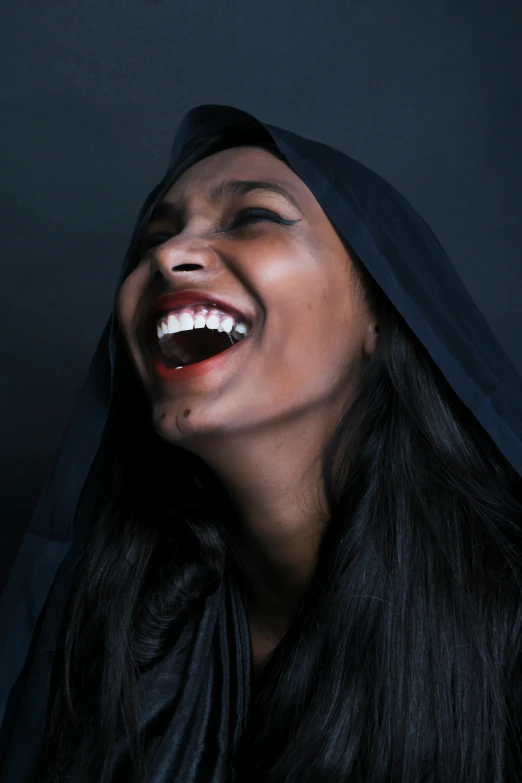 woman with mouth open and black hood smiling