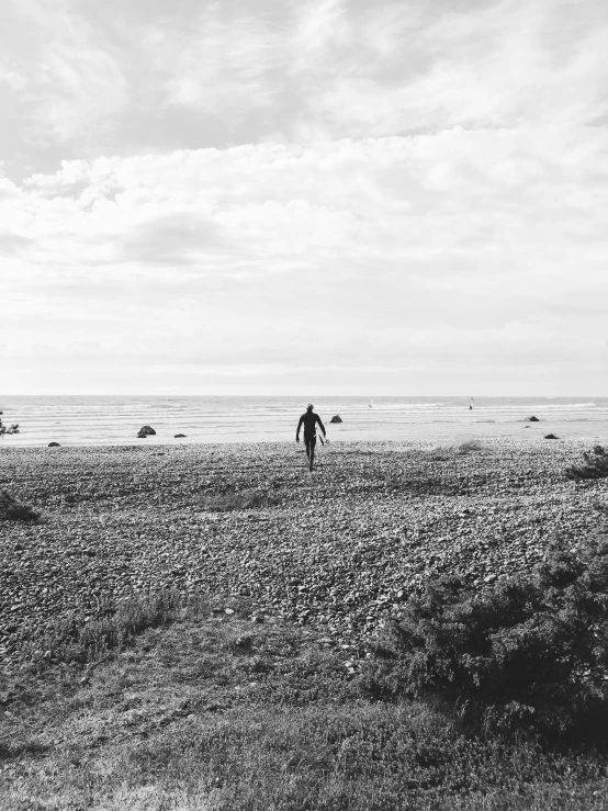 a group of people standing in an open field by the ocean