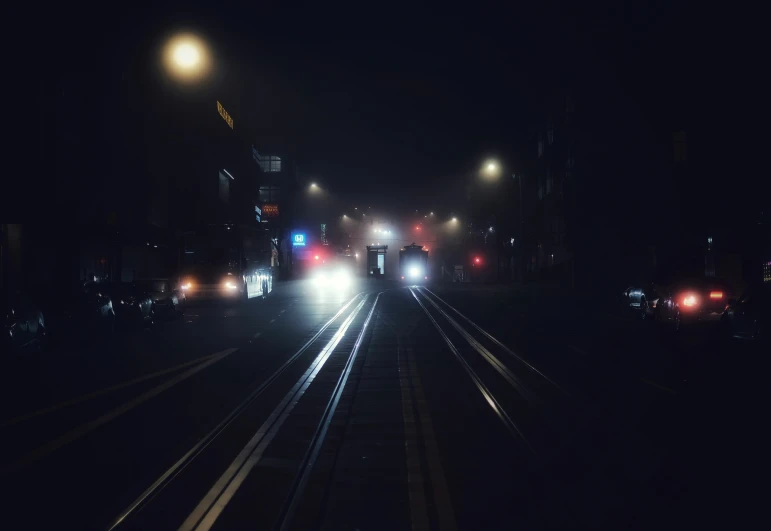 two cars in the middle of a street at night