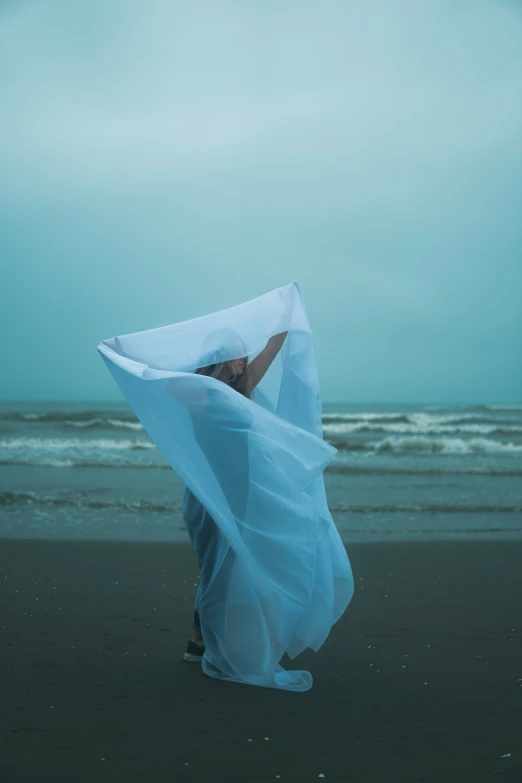 a woman on the beach covering her face