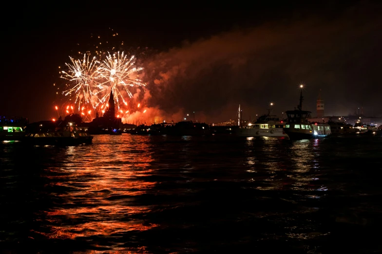 a fireworks is lit up at night over the water