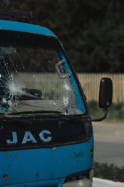 a broken glass in the windows of a blue truck