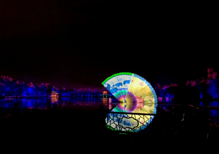 a large illuminated parasol sitting on top of a river