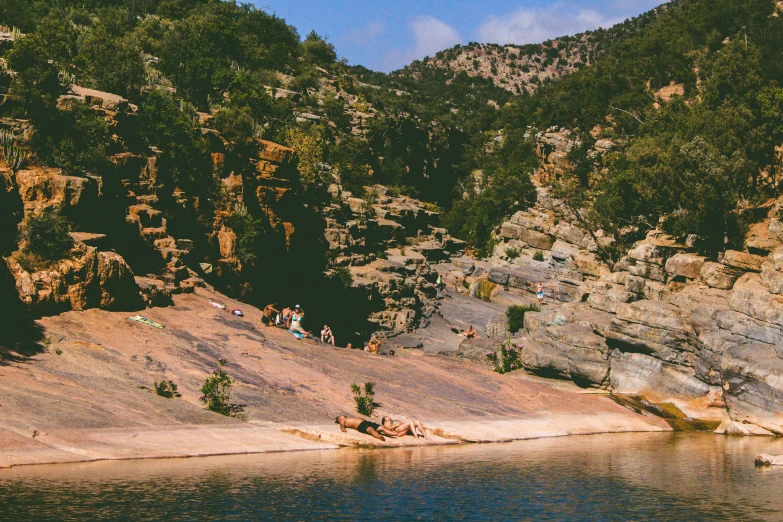 several people are bathing in a mountain lake