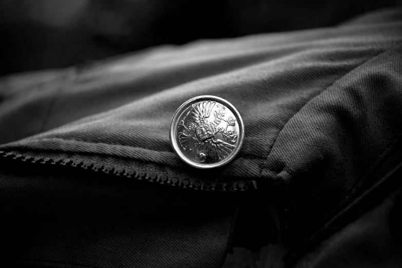 a close up of a person's pants with a silver tree of life patch