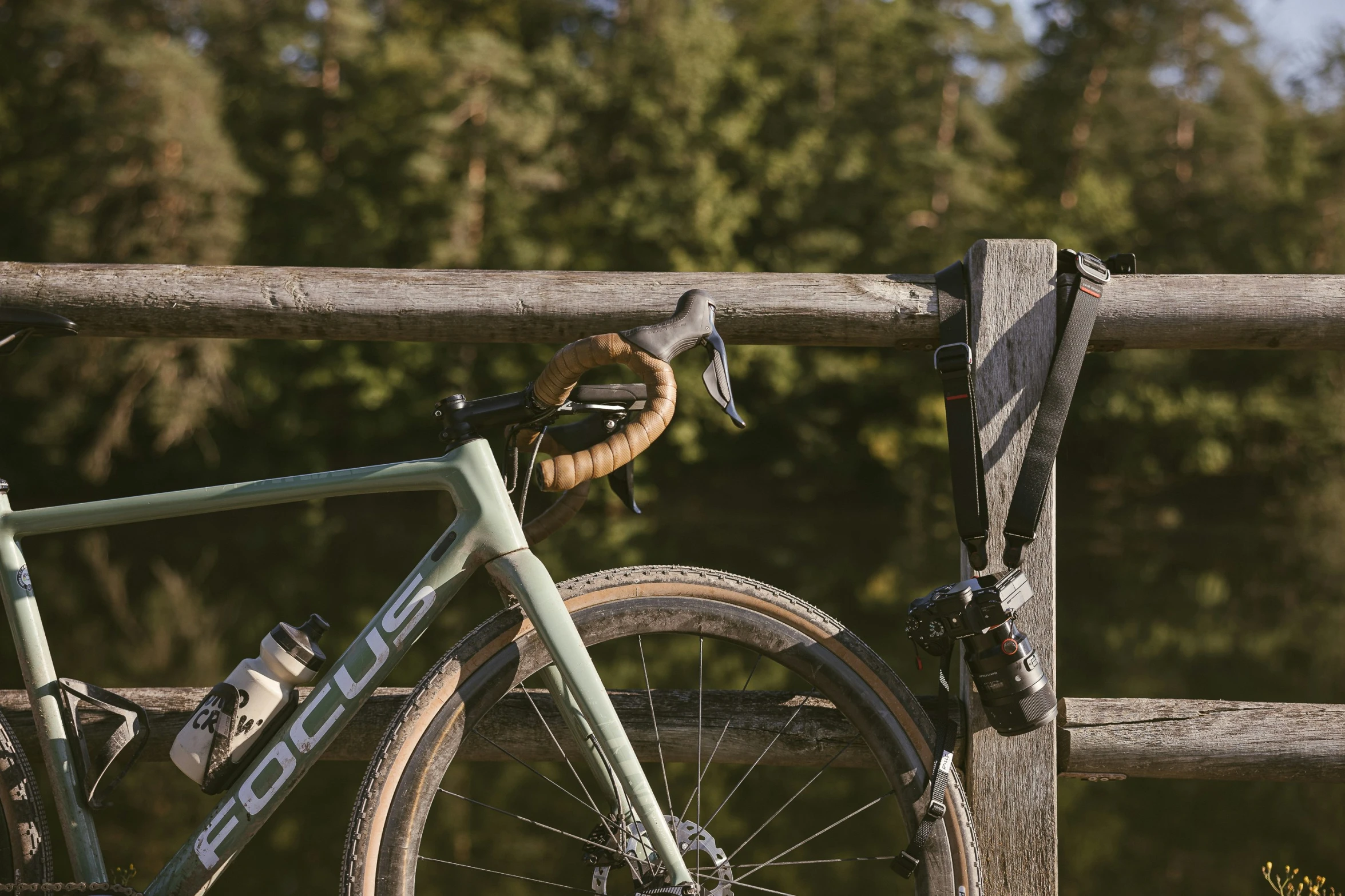 the bicycle is leaning against the wooden fence