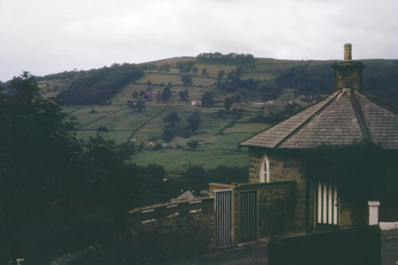 an old fashioned building near a hill in the country