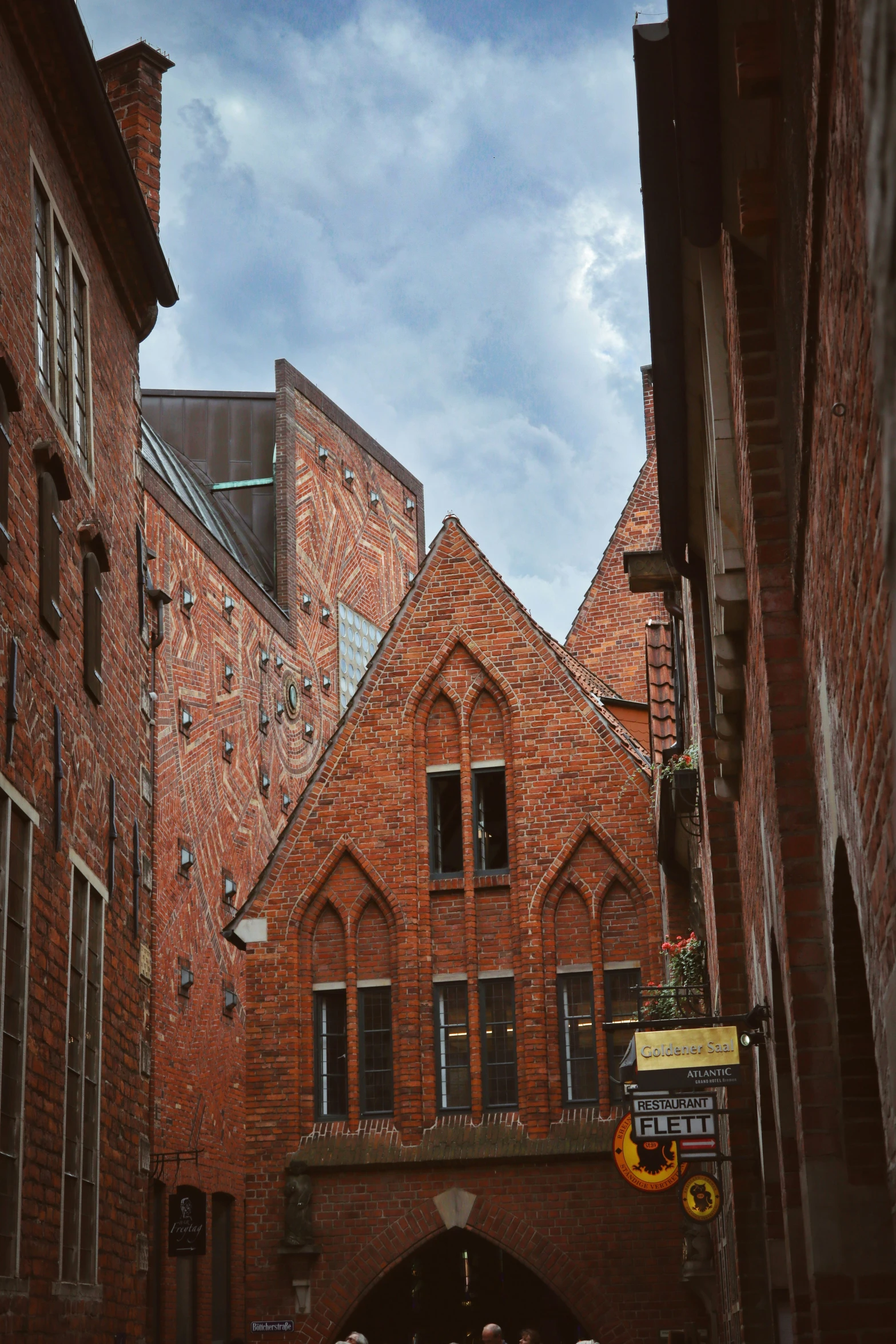 a brick alley has buildings and street signs