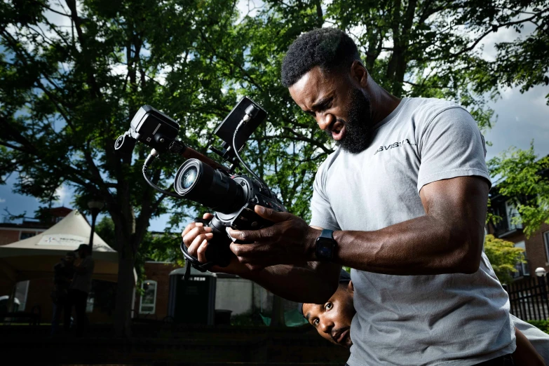 a man holding a camera and pointing at it