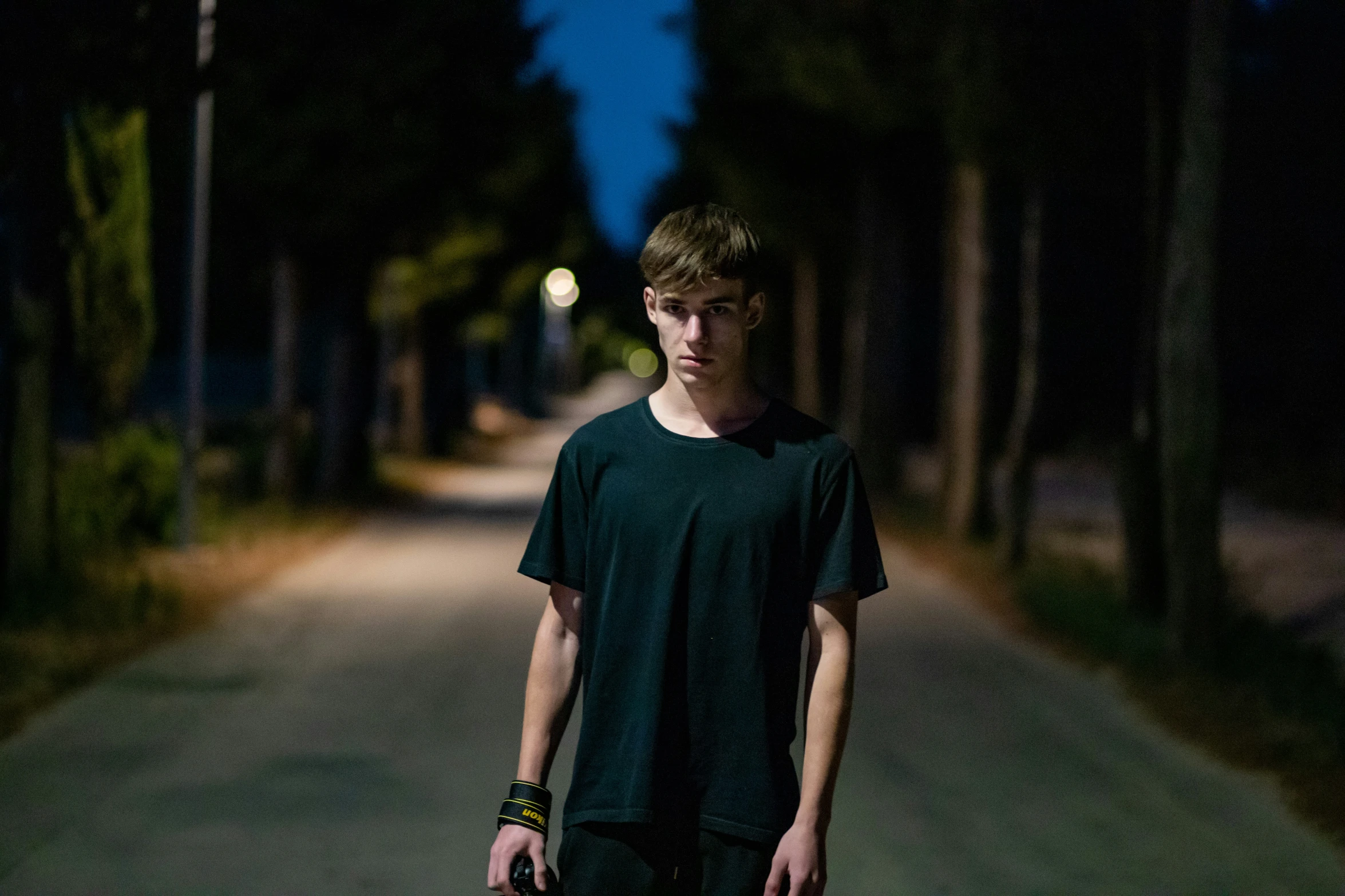 the young man is carrying his skateboard on the road