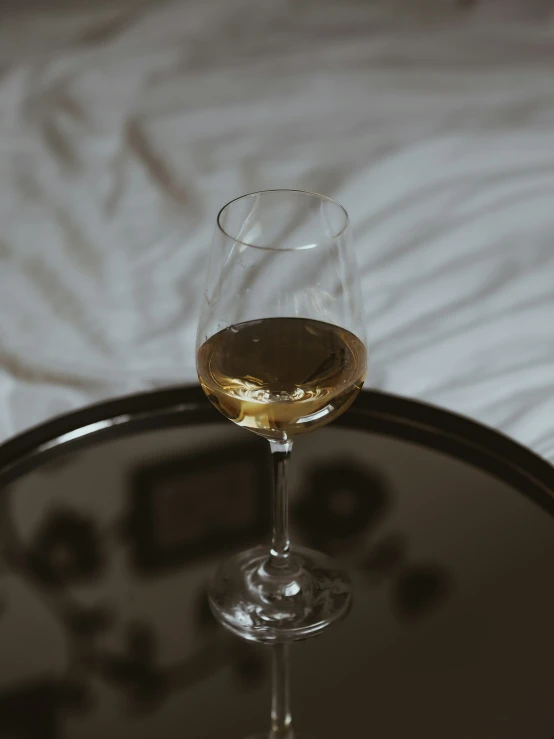 the glass of white wine is placed on a tray