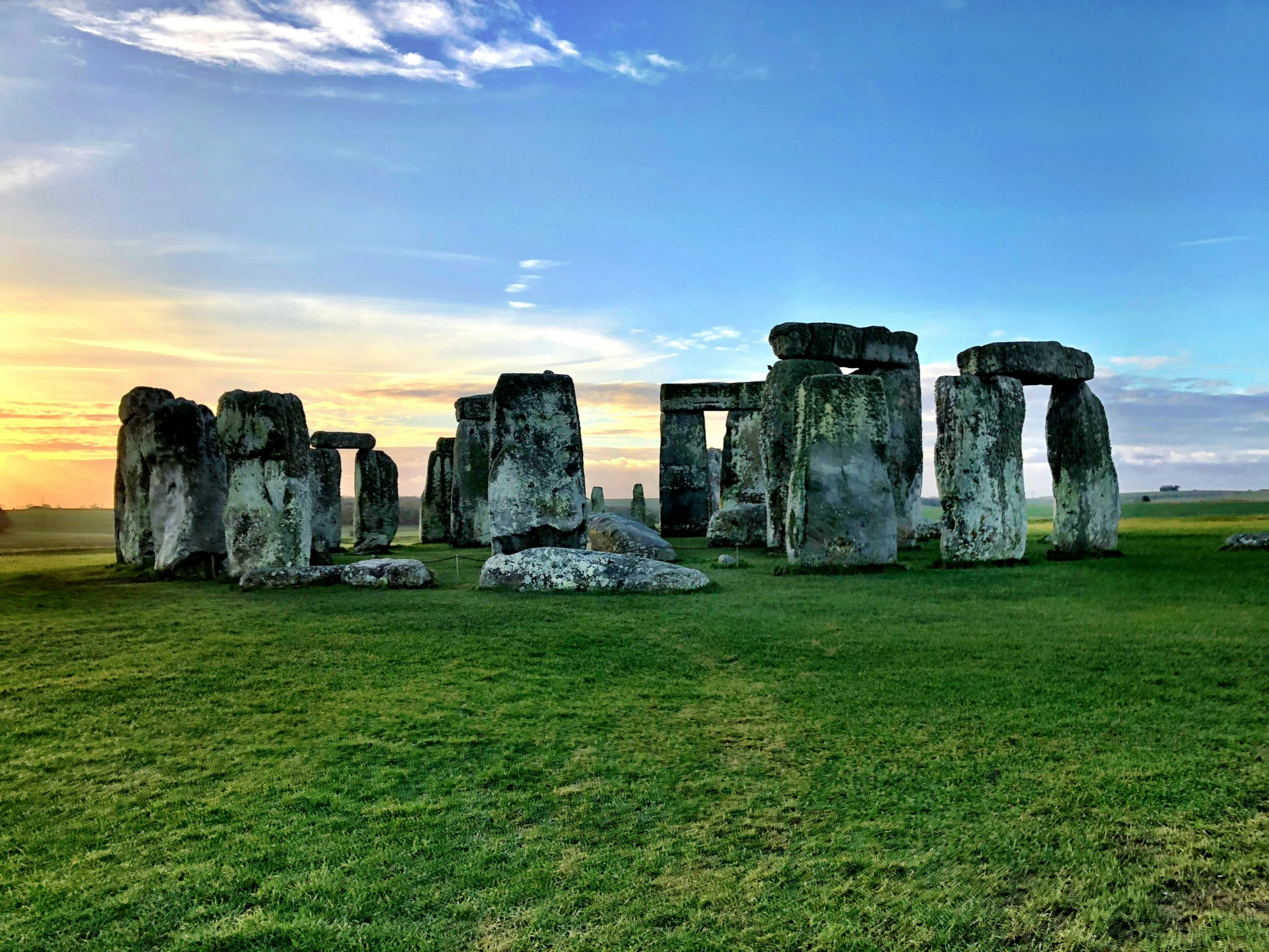 a stonehenge standing out on a grassy plain