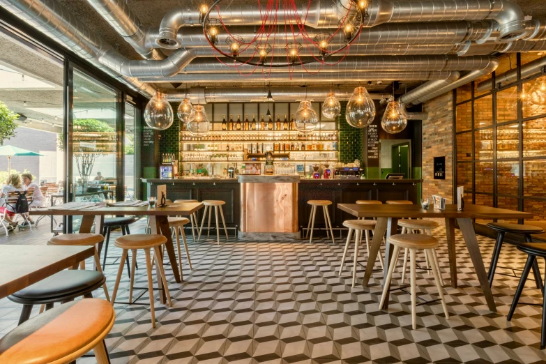 tables and chairs inside an industrial bar area