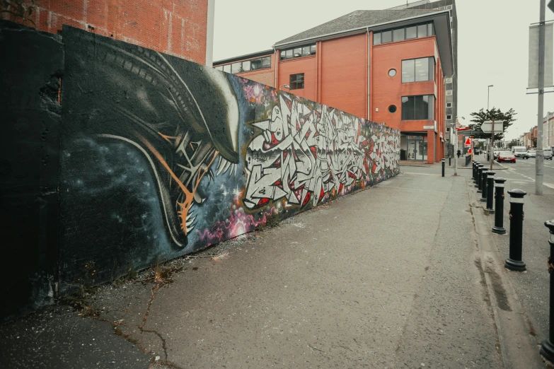 a wall with a painting on it near a curb