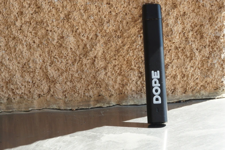 a black marker sitting next to a brown wall