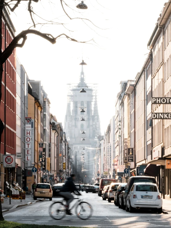 an urban street with cars, buses and bicycles