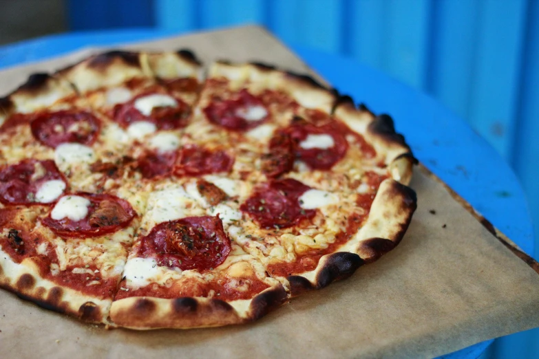 a pepperoni pizza is shown on top of brown paper