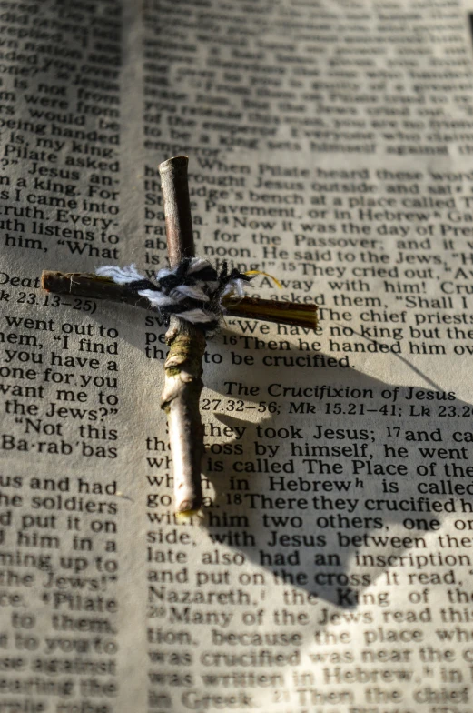 a cross on top of a piece of newspaper with a shadow