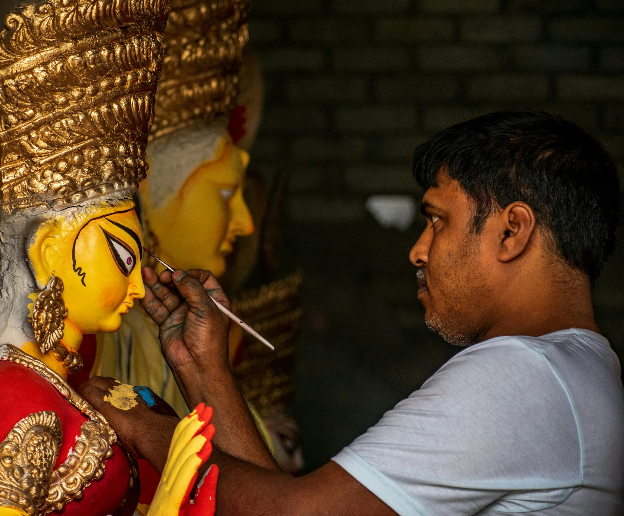 a man is sitting down painting a statue