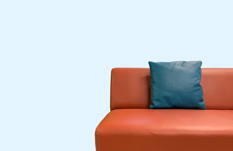 the corner of a couch in the foreground and an orange arm rest
