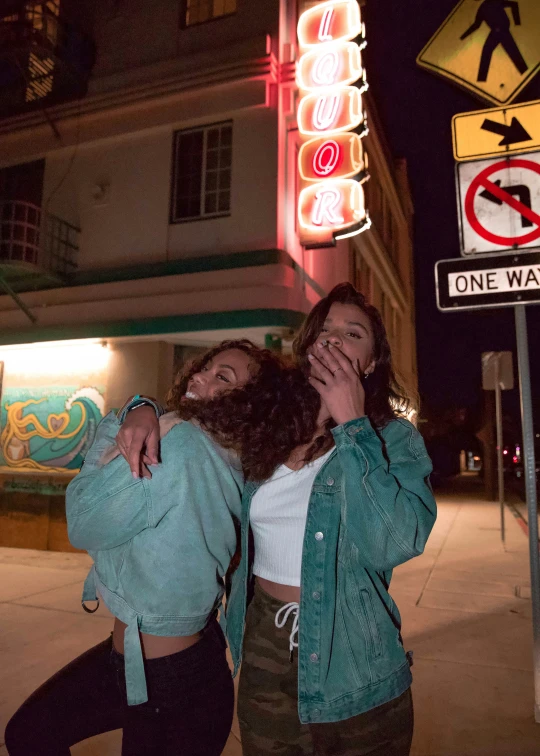 two girls standing together and one is holding up her cellphone