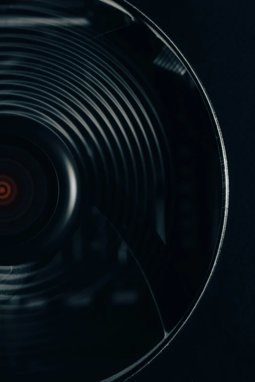 an open circular camera lens in black and red