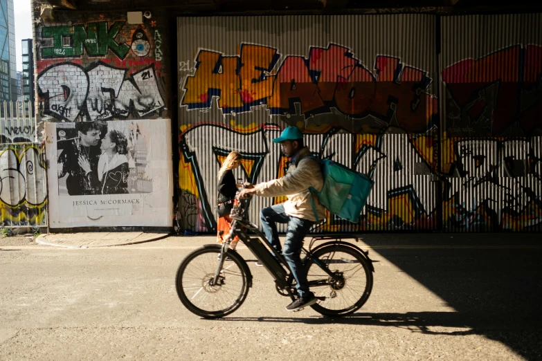 the person rides on a bike by graffiti