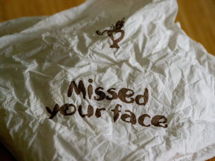 a white tissue with brown lettering that says missed your face