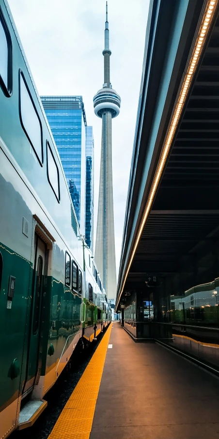 the train is next to the city and tall buildings