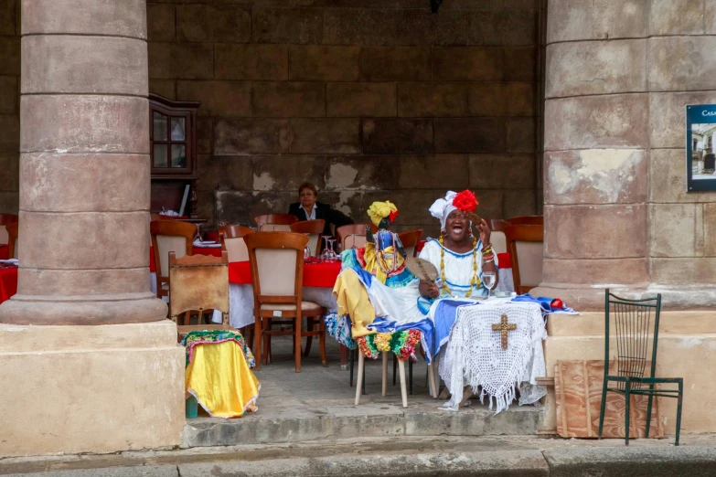 three women sitting on chairs in an outdoor room